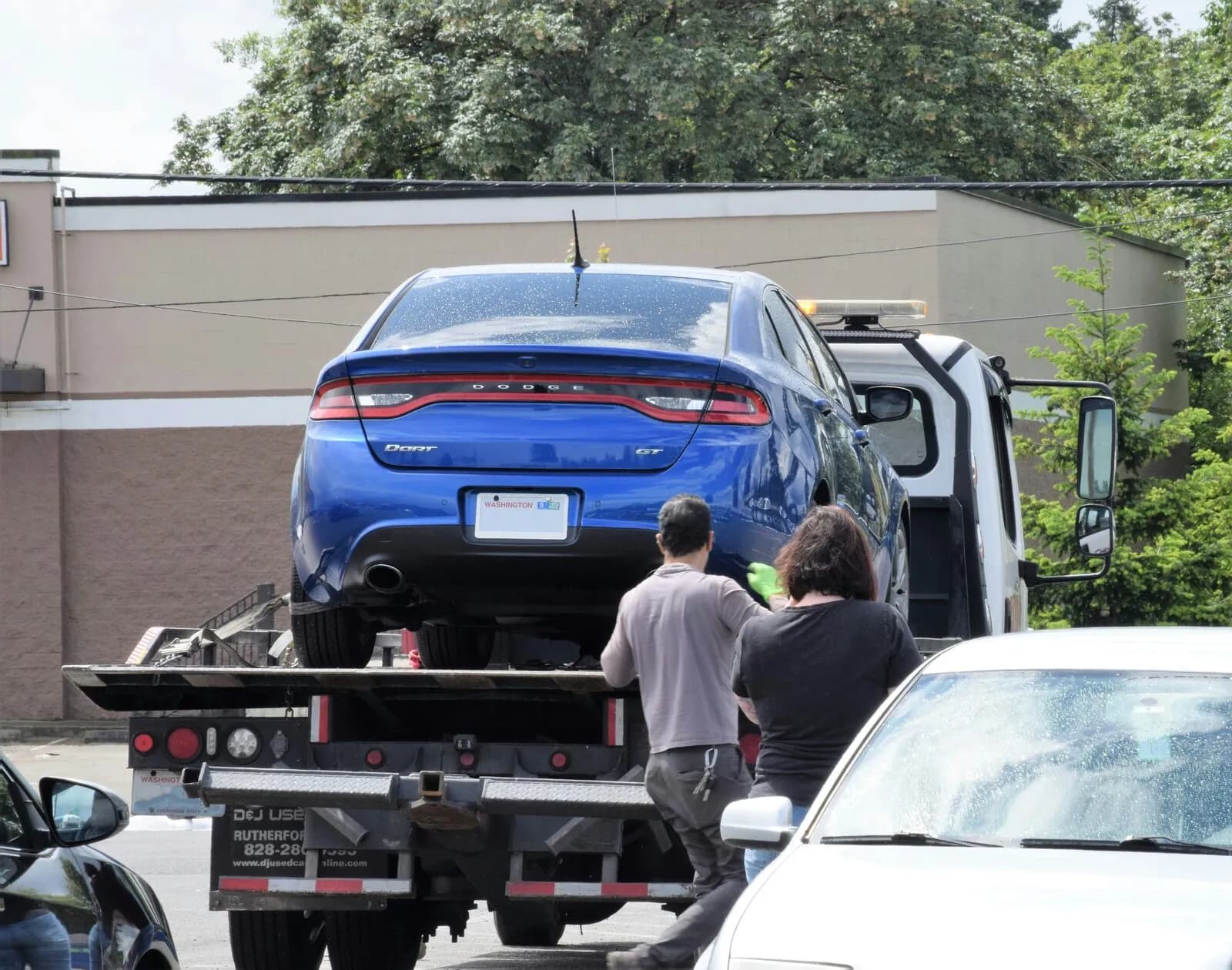 A vehicle being loaded onto a flatbed tow truck
